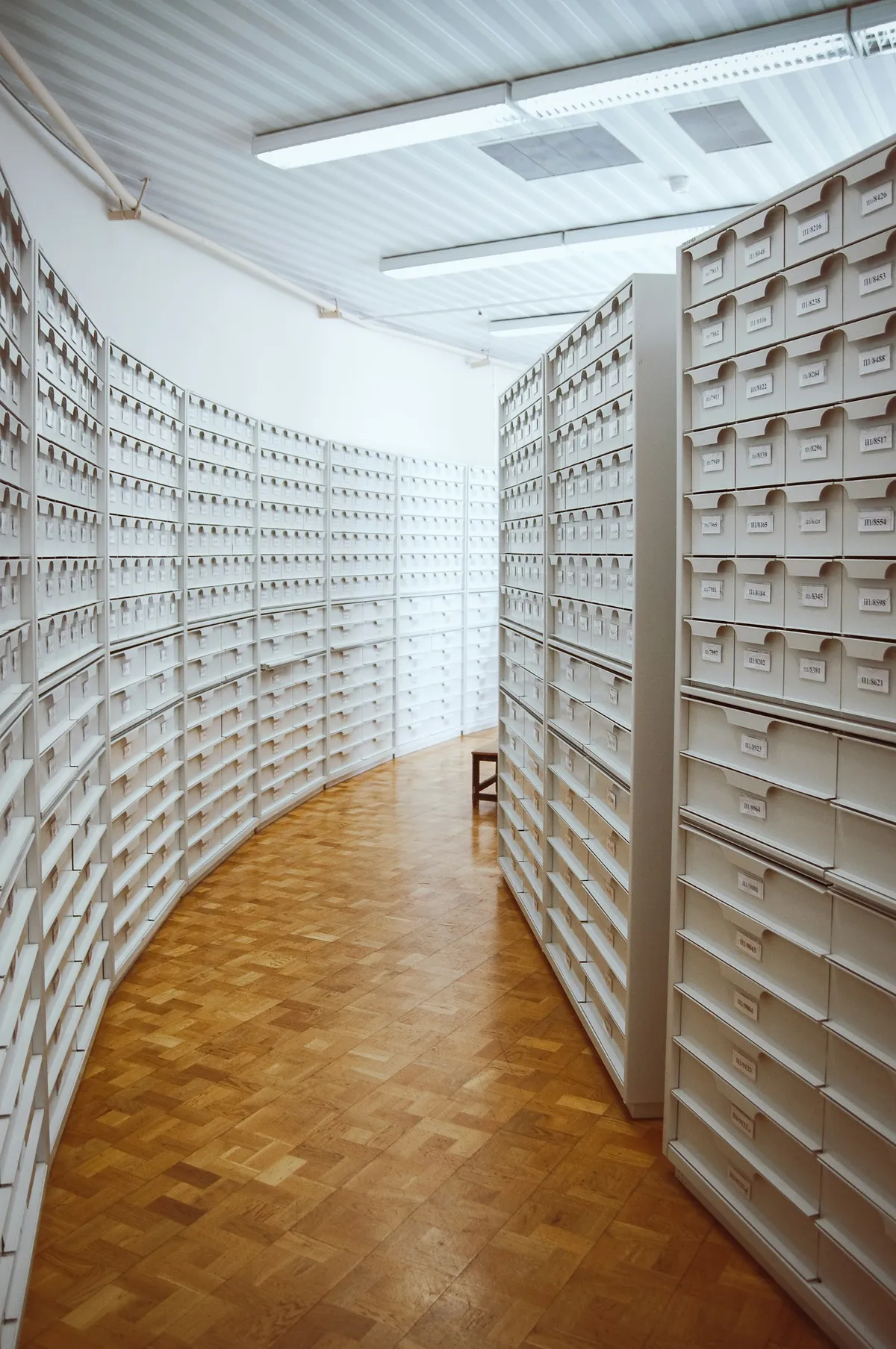 Gang zwischen weißen Karteischränken in einem Archiv